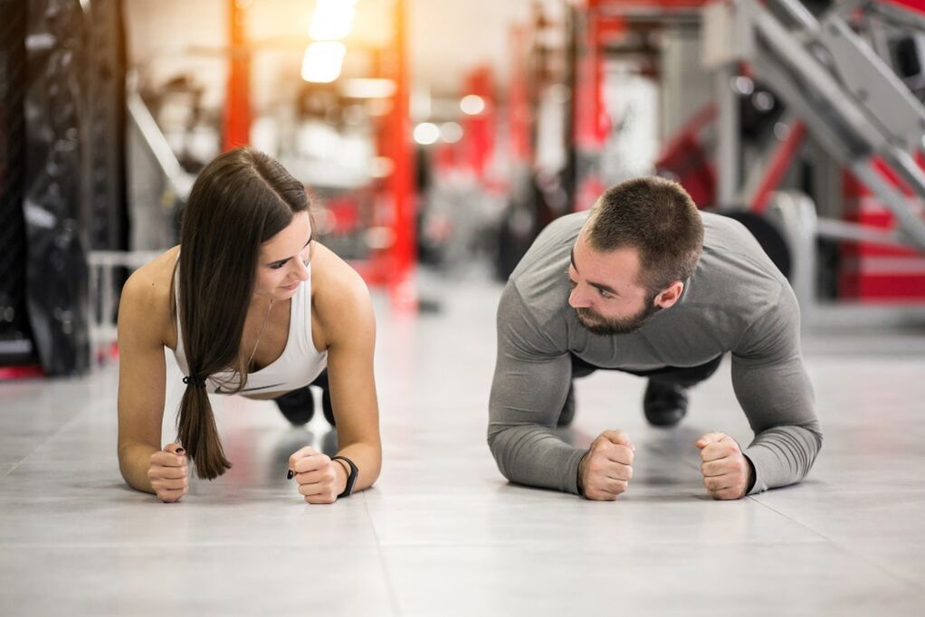 Vīrietis un sieviete veic Plank vingrinājumu, kas paredzēts visām muskuļu grupām